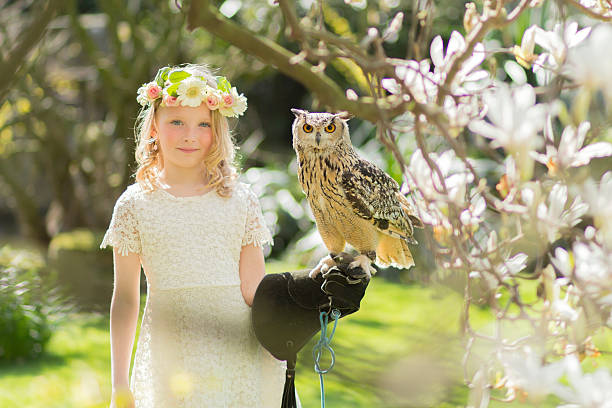 biondo ragazza in con un gufo in un albero di magnolia - child portrait fine art portrait multi colored foto e immagini stock