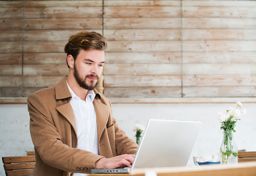 Man working on laptop at cafe