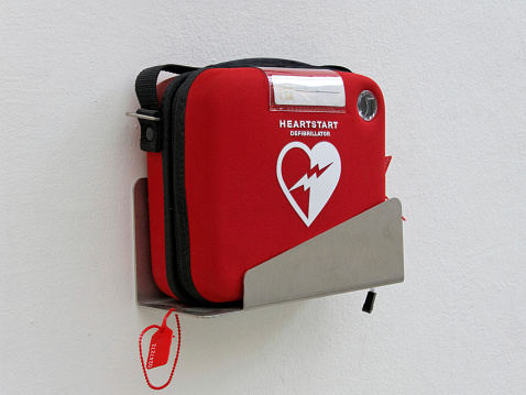 Nuremberg, Germany - October 30, 2014: Red heartstart external Defibrillator hangs on a white wall in a museum in Germany, Nuremberg.