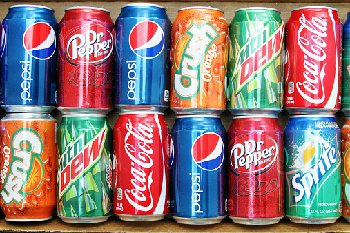 West Palm Beach, USA - March 29, 2011: Variety of brand name soda cans placed in a box in a double row. Brands include Coca Cola, Pepsi, Dr Pepper, Orange Crush, Sprite and Mountain Dew.