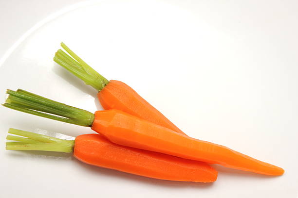istock fresh baby carrot on white background. 521179221