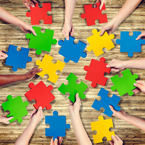 istock Group of Hands Holding Jigsaw Puzzle 521181961