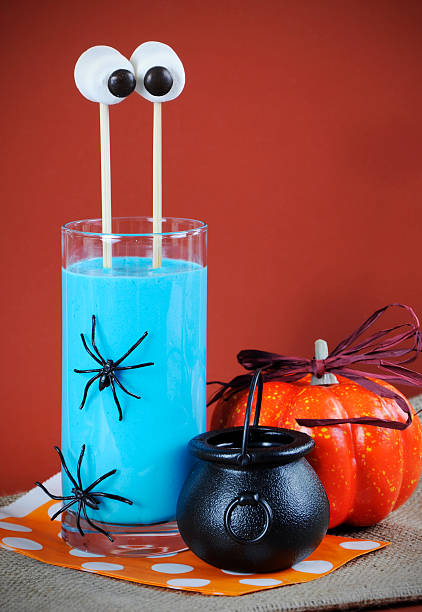 Happy Halloween blue smoothie drink with marshmallow eyes Happy Halloween marshmallow extended martian eyes in blue banana smoothie for fun party drink. partytime stock pictures, royalty-free photos & images