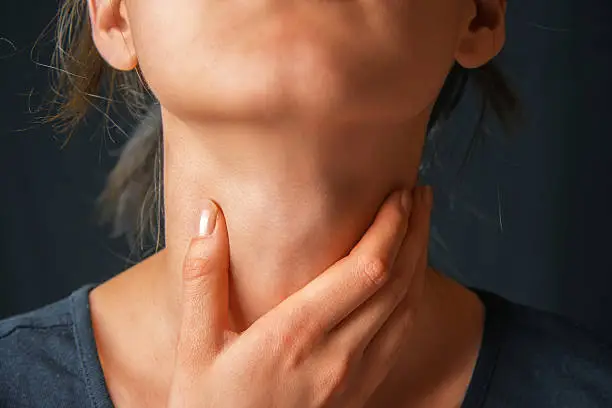 Photo of Woman holds her throat, sore throat
