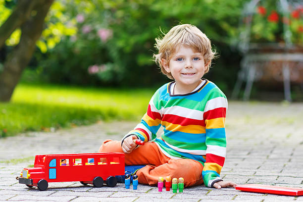 istock Little preschool boy playing with car toy 521184989