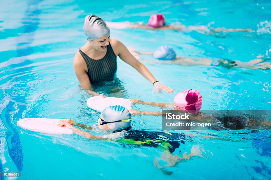 Les enfants ayant une course au cours de natation - Photo de Natation libre de droits