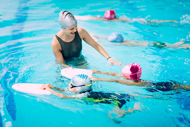 les enfants ayant une course au cours de natation - descriptive color elementary student water blue photos et images de collection