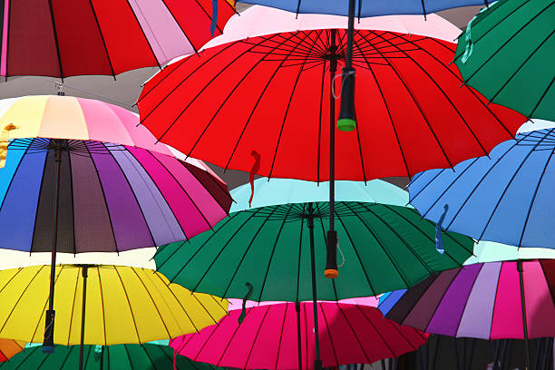 istock Collection of multi colored umbrellas hanging up. 521186339