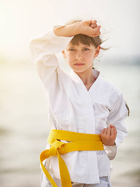 istock Little girl practicing karate on the beach 521198595