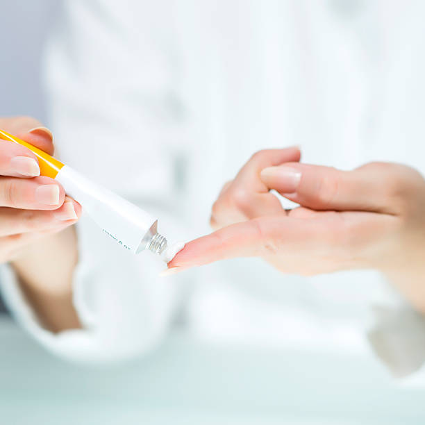 Woman's hands with white cream tube