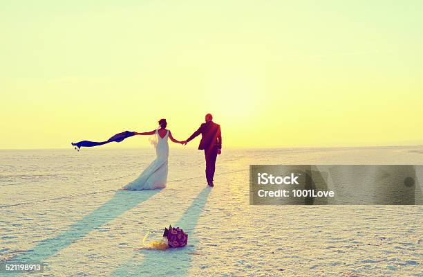 Happy Couple Walking On Snow Stock Photo - Download Image Now - 30-34 Years, 30-39 Years, 35-39 Years