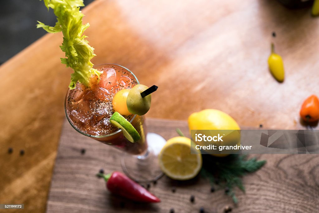 Vodka Bloody Mary Bloody Mary vodka based alcoholic drinks on ice garnished with olive, tomato, lime and lemon, celery Black Peppercorn Stock Photo