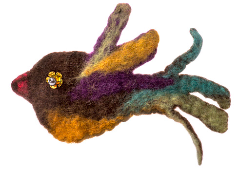 Brooch made of felt wool in the form of a bird on a white background
