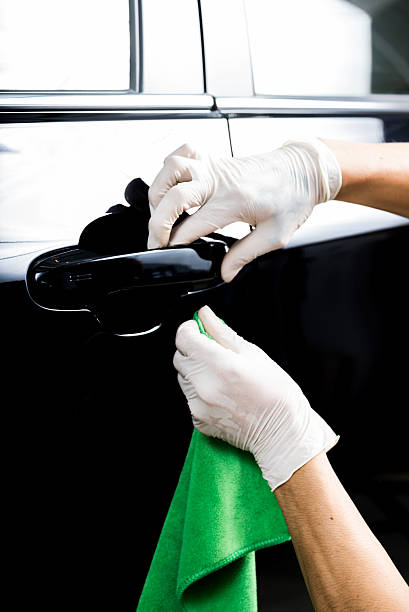 istock Car detailing series : Worker cleaning black car 521199590