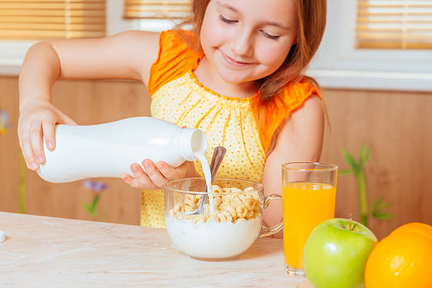 istock Girl pours milk for healthy breakfast 521199629