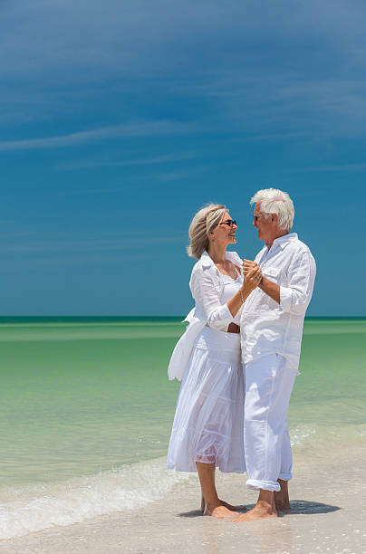 istock Happy Senior Couple Dancing Holding Hands on Beach 521200679