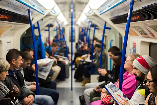 Inside a London underground train London, UK - 24 October 2014: People sitting on a Victoria Line underground train in London. London Underground carried a record 1.26 billion passengers in the 2013-2014 year. london england rush hour underground train stock pictures, royalty-free photos & images