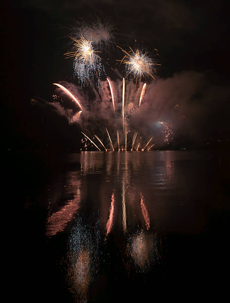 istock Colorful fireworks on black sky background with water reflections 521200917
