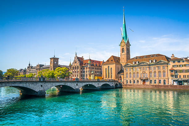 Historic city of Zurich with river Limmat, Switzerland Panoramic view of the historic city center of Zurich with famous Fraumunster Church and munsterbrucke with river Limmat on a sunny day with blue sky, Canton of Zurich, Switzerland zurich photos stock pictures, royalty-free photos & images