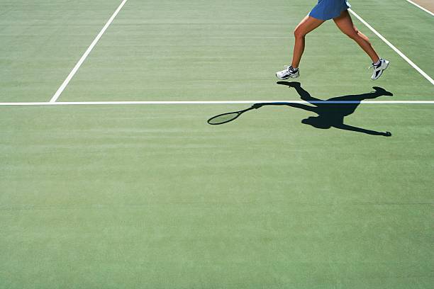 тень и ноги человека, играющего в теннис - muscular build athlete tennis women стоковые фото и изображения