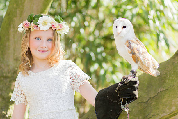 fille blonde avec un hibou dans un arbre de magnolia - formal garden ornamental garden child single flower photos et images de collection