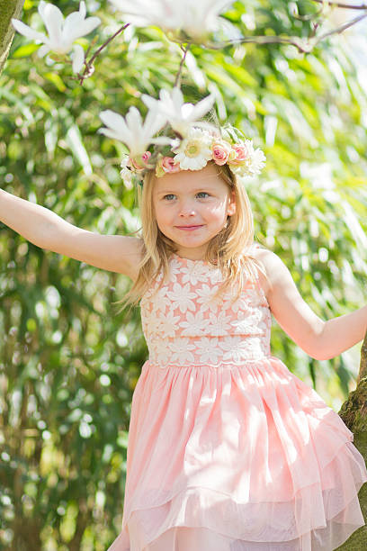 biondo ragazza in un albero di magnolia - child portrait fine art portrait multi colored foto e immagini stock