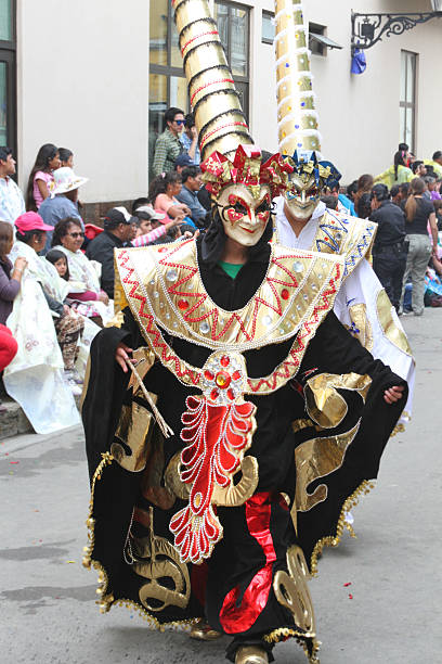 Costumed Figures Marching in Carnival Parade, Peru Cajamarca, Peru - February 7, 2016 Two masked and costumed figures march in the Carnival Parade in Cajamarca, Peru while the crowd watches on February 7, 2016 cajamarca region stock pictures, royalty-free photos & images