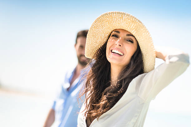 felicidad pareja en la playa - women summer hat beach fotografías e imágenes de stock