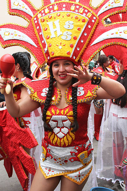 Pretty Young Woman Marches in Carnival Parade, Peru Cajamarca, Peru - February 7, 2016 Pretty, smiling young woman in red and gold costume and headdress marches in Carnival Parade in Cajamarca, Peru on February 7, 2016 cajamarca region stock pictures, royalty-free photos & images