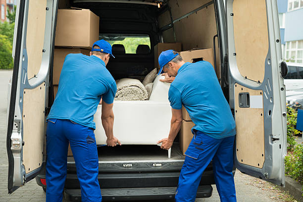 due lavoratori regolazione divano in camion - attività fisica foto e immagini stock