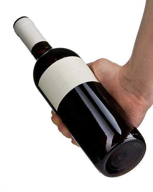 istock Man's hand is holding unopened red wine bottle 521207638