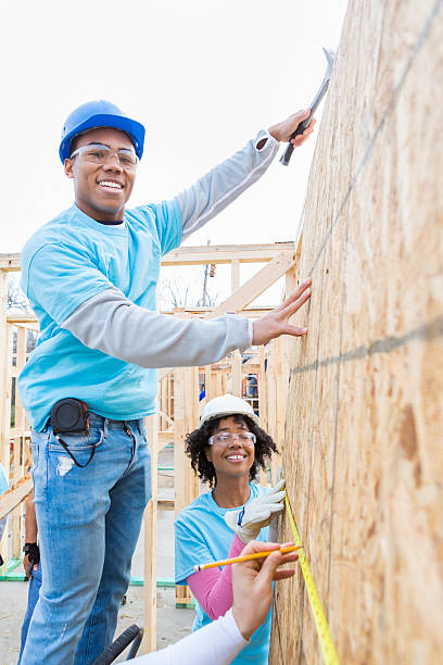 istock Man on ladder builds charity home 521209524