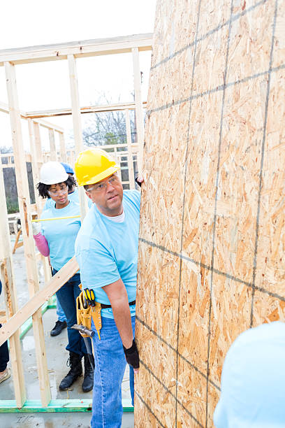 istock Mature man moves plywood at construction site 521209572