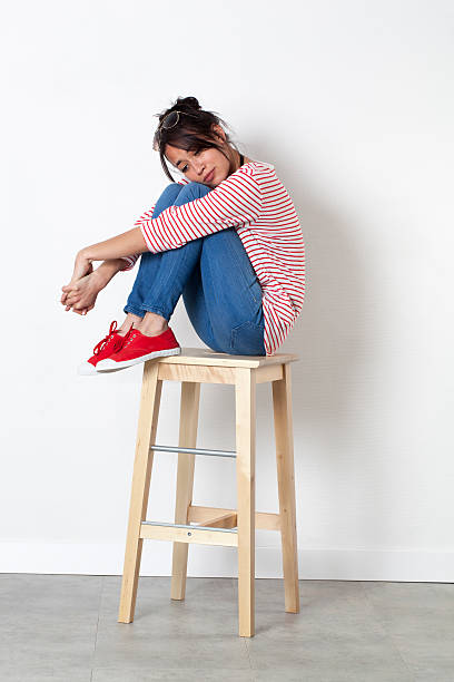 istock feeling depressed for sad beautiful young woman sitting on stool 521210076