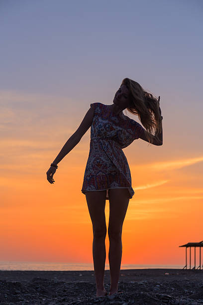 istock Beautiful young woman on the beach at sunset 521211646