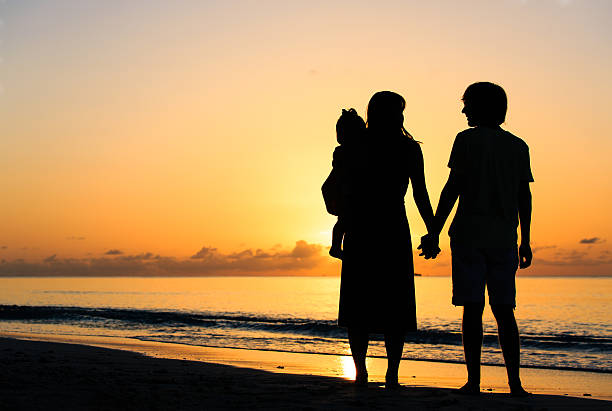 istock romantic couple with little child at sunset tropical beach 521212026