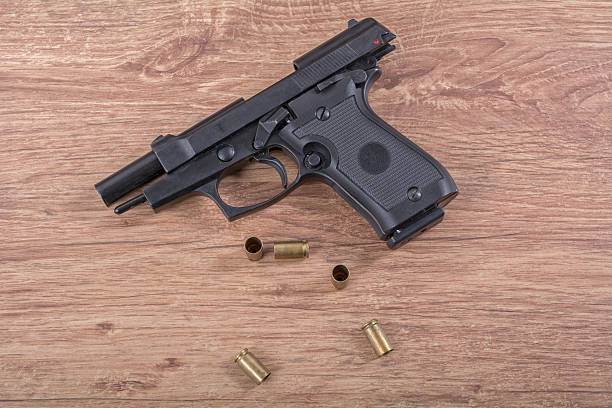 istock The gun with the bullets on a wooden background 521223700