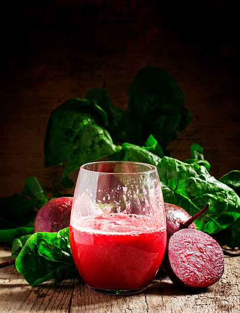 Large glasses with red beet juice, fresh beetroot with tops