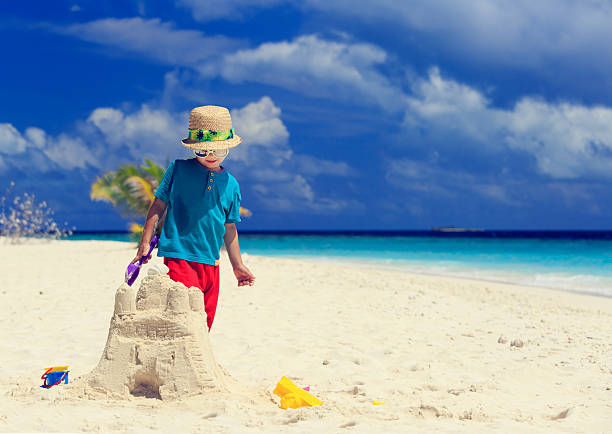 istock little boy building sand castle on beach 521226385