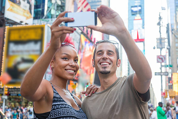 istock Young Couple Taking Selfie in Times Square 521227283