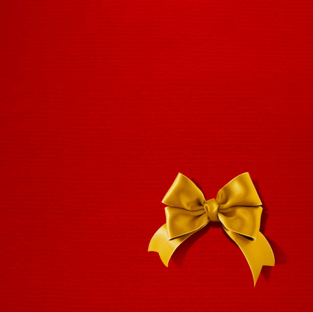 istock Double bow gold ribbon on red texture gift paper 521227977