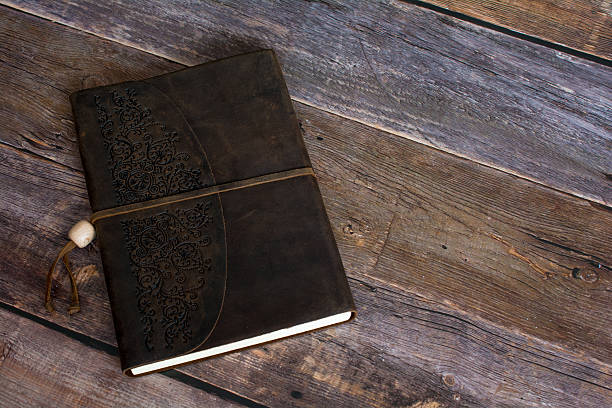 istock Leather Bound Journal Book on a Old Barn Board Floor 521228290