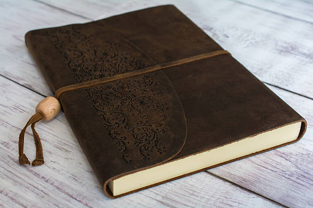istock Leather Bound Journal Book on White Barn Board Close Up 521228304