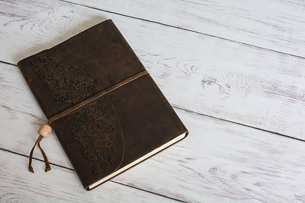 istock Leather Bound Journal Book on a White Barn Board Floor 521228318