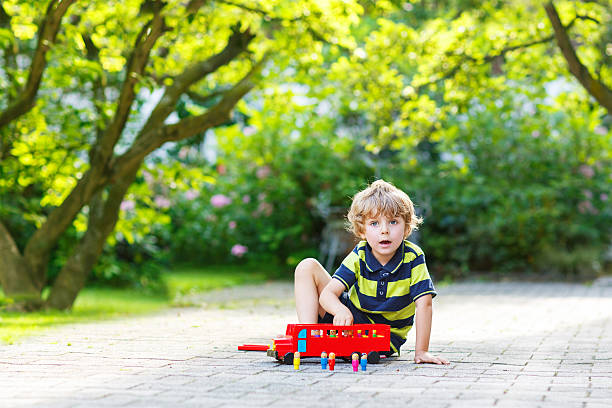 istock Little preschool boy playing with car toy 521228569