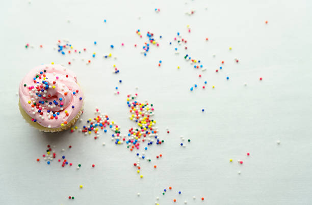 Homemade strawberry sorbet. A single creamy strawberry ice cream scoop with sugar sprinkle dots on a white background.