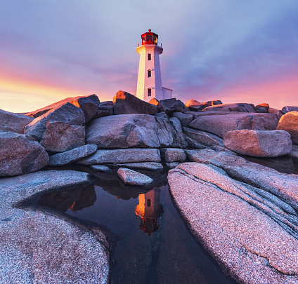 Peggy's Cove Lighthouse and the surrounding granite landscape absorb the rich colours of a Spring sunset.