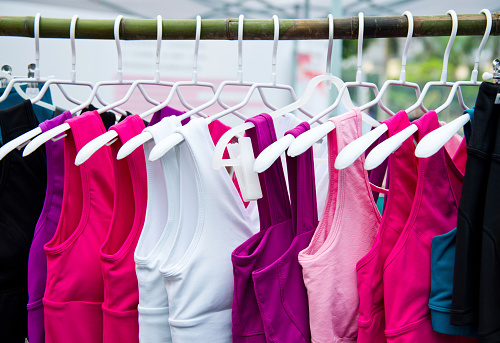 Colorful female t-shirts on a clothing rack.