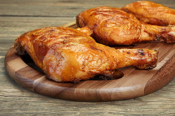 Three Grilled BBQ Chicken Leg Quarter On Wood Board stock photo