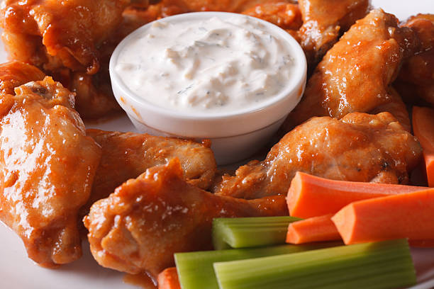 istock fast food: buffalo wings with sauce on a plate macro 521232270